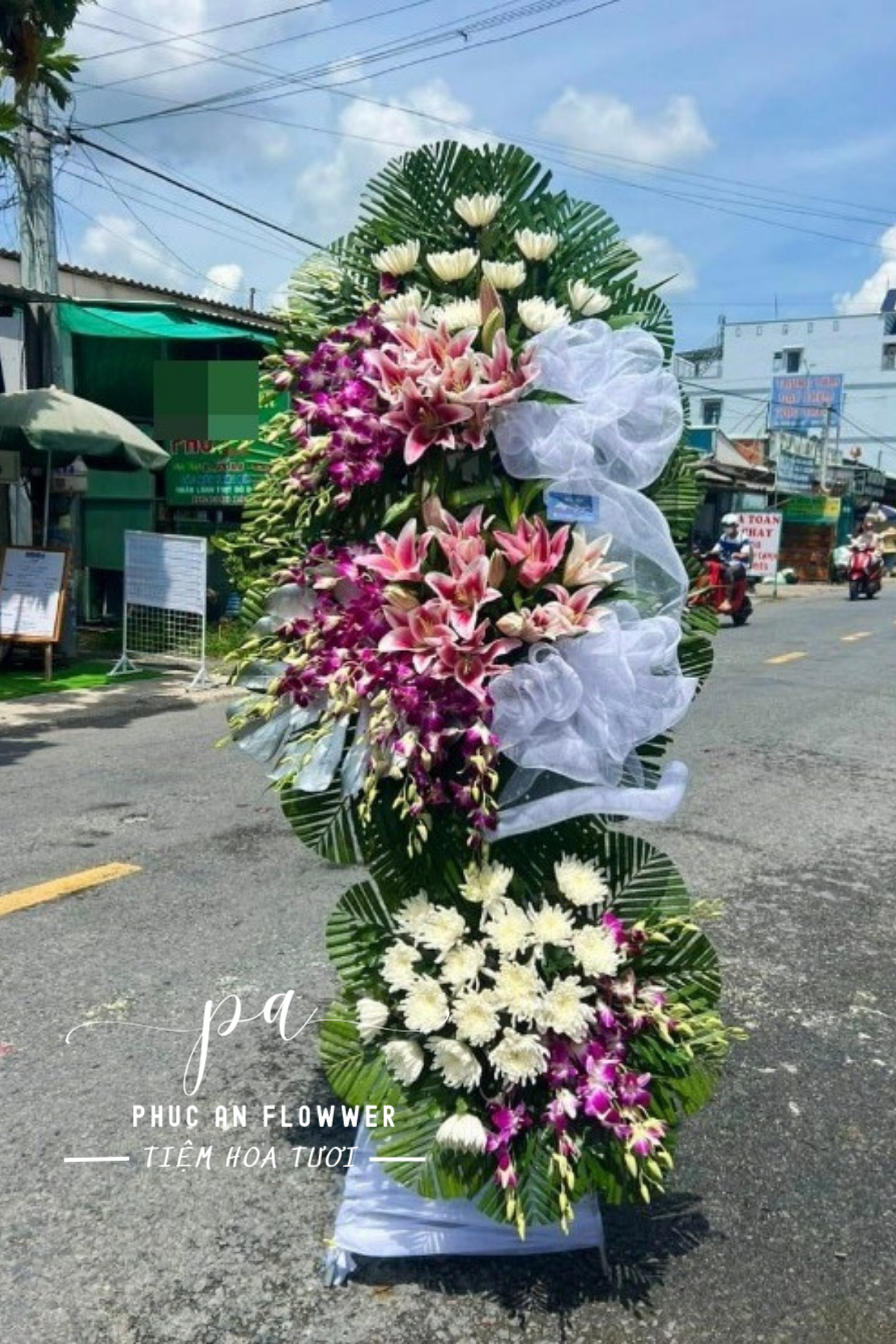 kệ hoa chia buồn lan tím hoa ly hồng cúc trắng thiết kế sang trọng trang nghiêm dùng trong tang lễ thể hiện sự kính viếng và chia sẻ nỗi mất mát cùng gia quyến