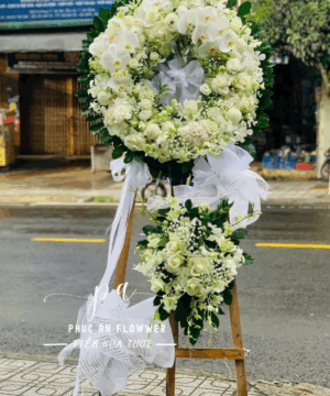 Vòng hoa chia buồn lan hồ điệp trắng, kệ hoa tang lễ tông trắng kem trang nhã, vòng hoa viếng đám tang sang trọng, hoa chia buồn thiết kế tròn truyền thống, đặt hoa tang lễ giao nhanh tận nơi