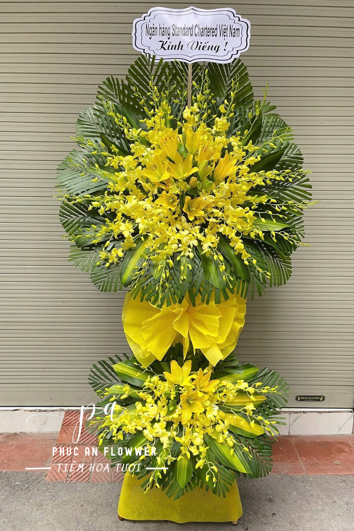 Kệ hoa chia buồn lan mokara vàng hai tầng, hoa ly vàng viếng tang lễ, kệ hoa tang tông vàng trang nghiêm sang trọng, hoa chia buồn cao cấp giao nhanh tận nơi
