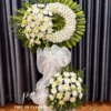Kệ hoa chia buồn vòng lan trắng cao cấp, hoa cúc kem trang nghiêm, kệ hoa viếng thiết kế vòng nguyệt quế sang trọng, hoa tang lễ tông trắng xanh thanh nhã